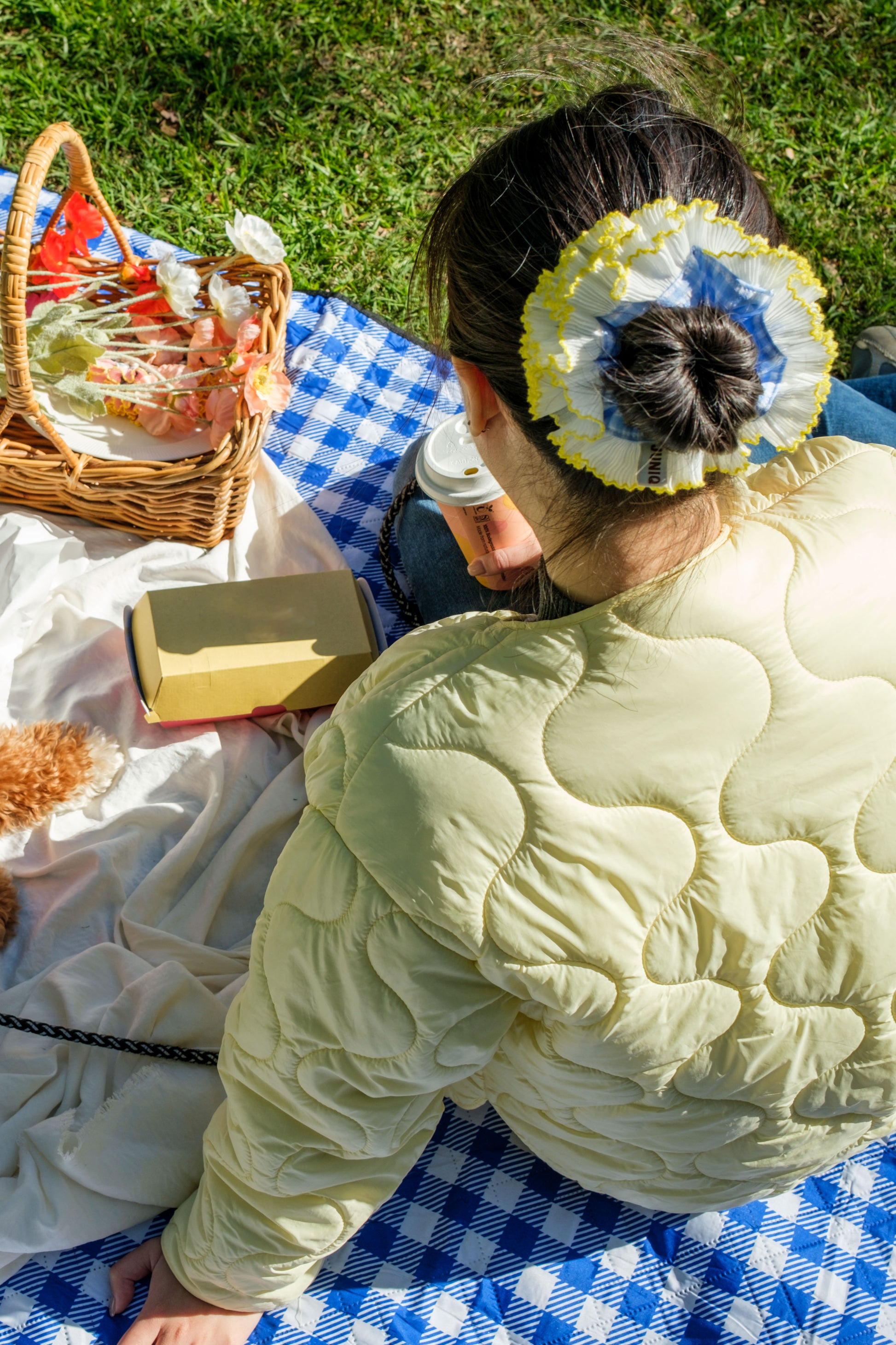 model wearing juniq brand scrunchie, double frilled, blue gingham, white yellow ruffle trim, in her bun