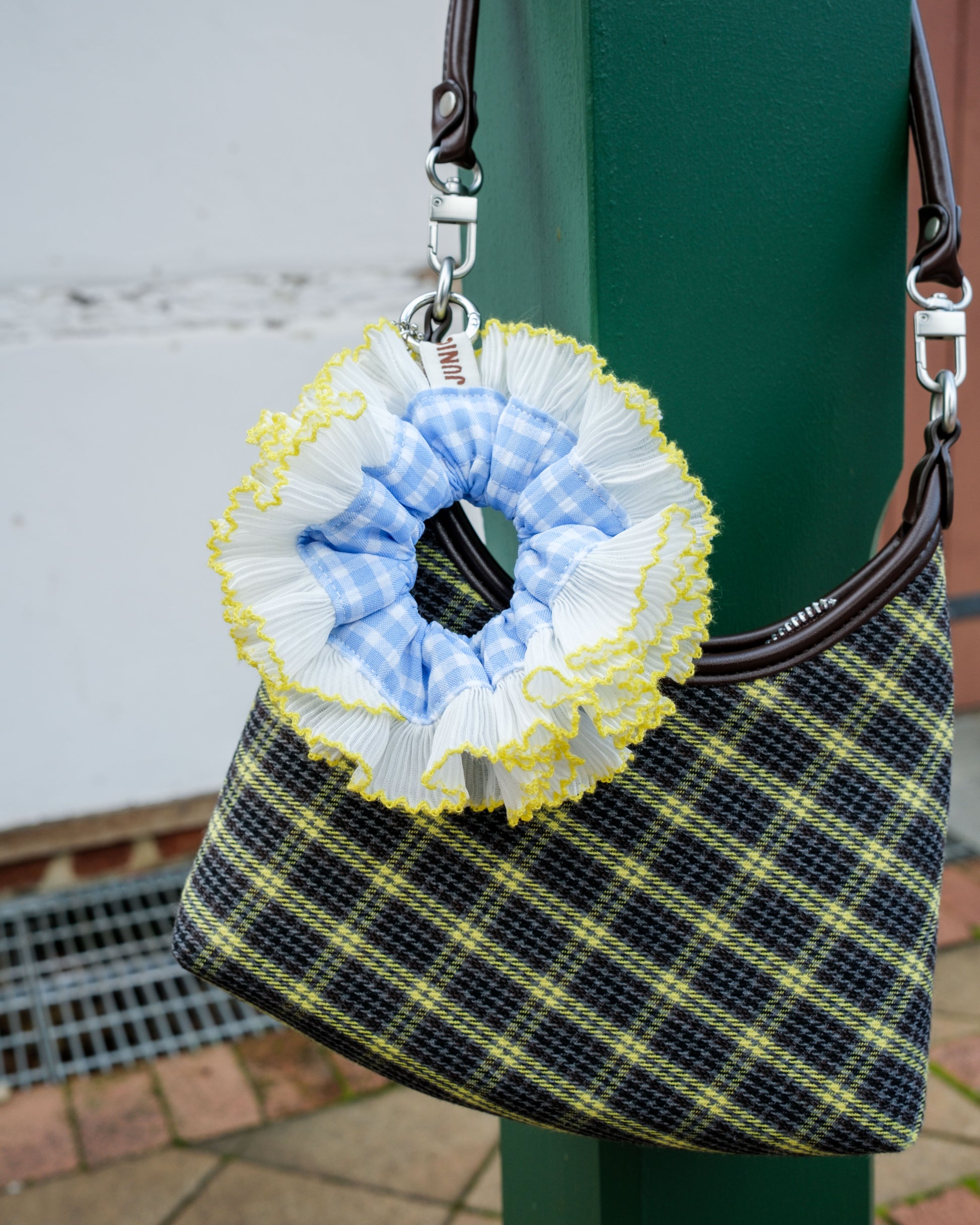 blue white yellow scrunchie bag charm on a pleated bag