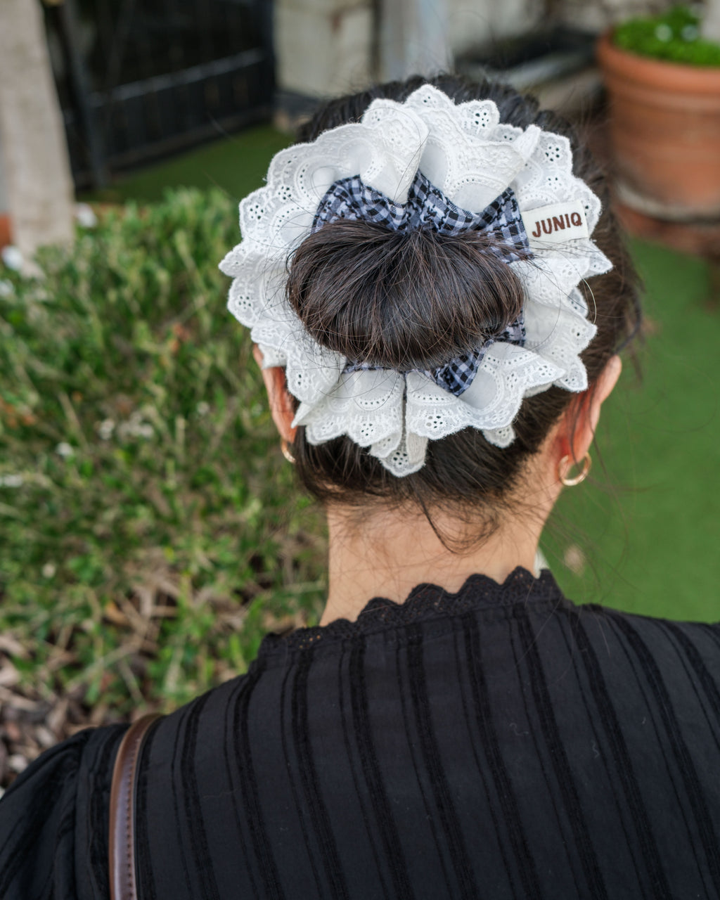 model wearing juniq brand scrunchie, black gingham, embroidered white trim