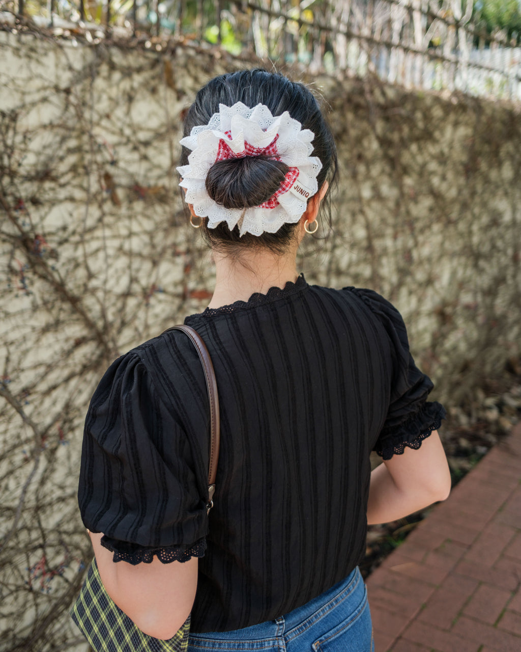 model wearing juniq brand scrunchie, red gingham, embroidered white trim