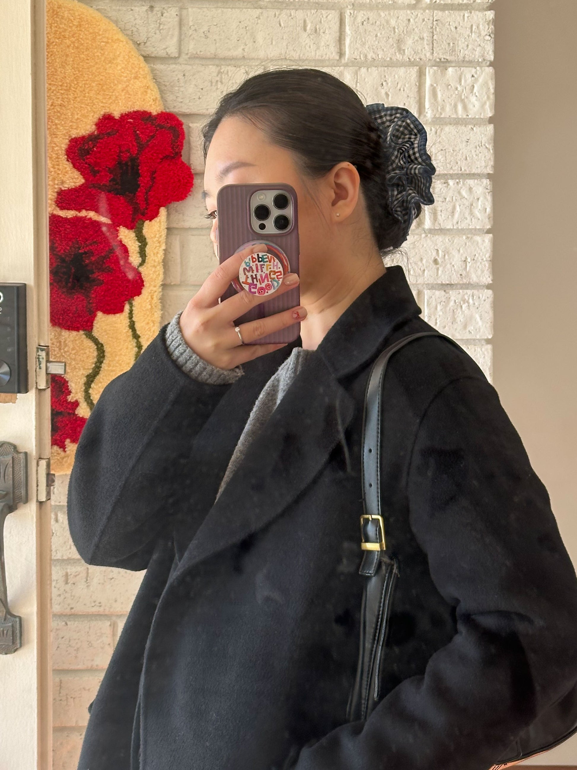 model wearing juniq brand scrunchie, black gingham checkered, blue overlocked trim, quad layers
