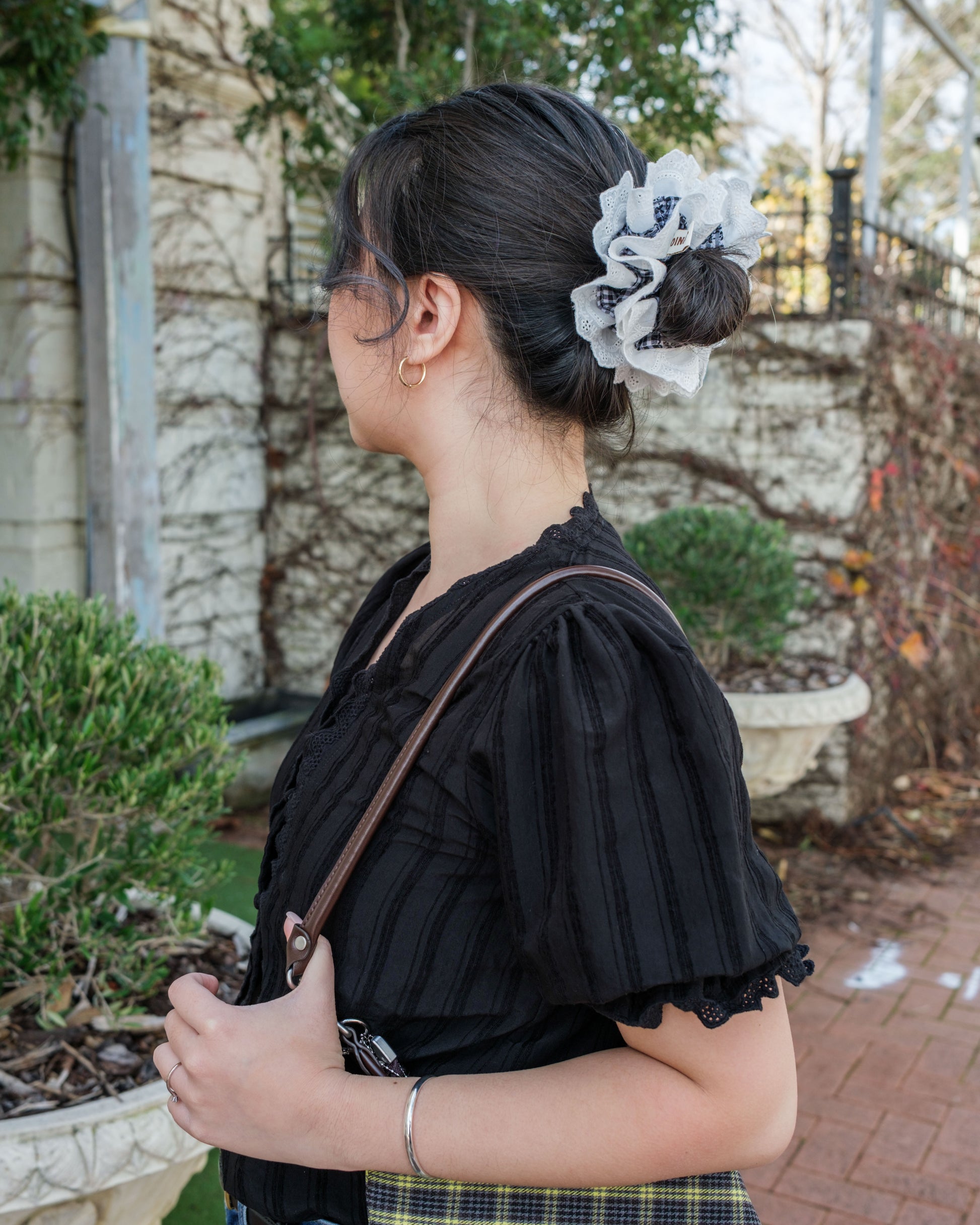 model with juniq brand scrunchie bella gingham style, black gingham white embroidered trim