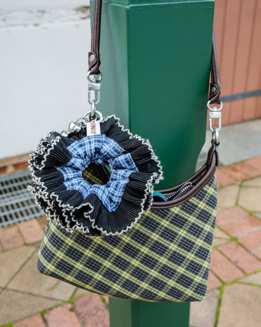 blue-black scrunchie keychain attached to a plaid bag