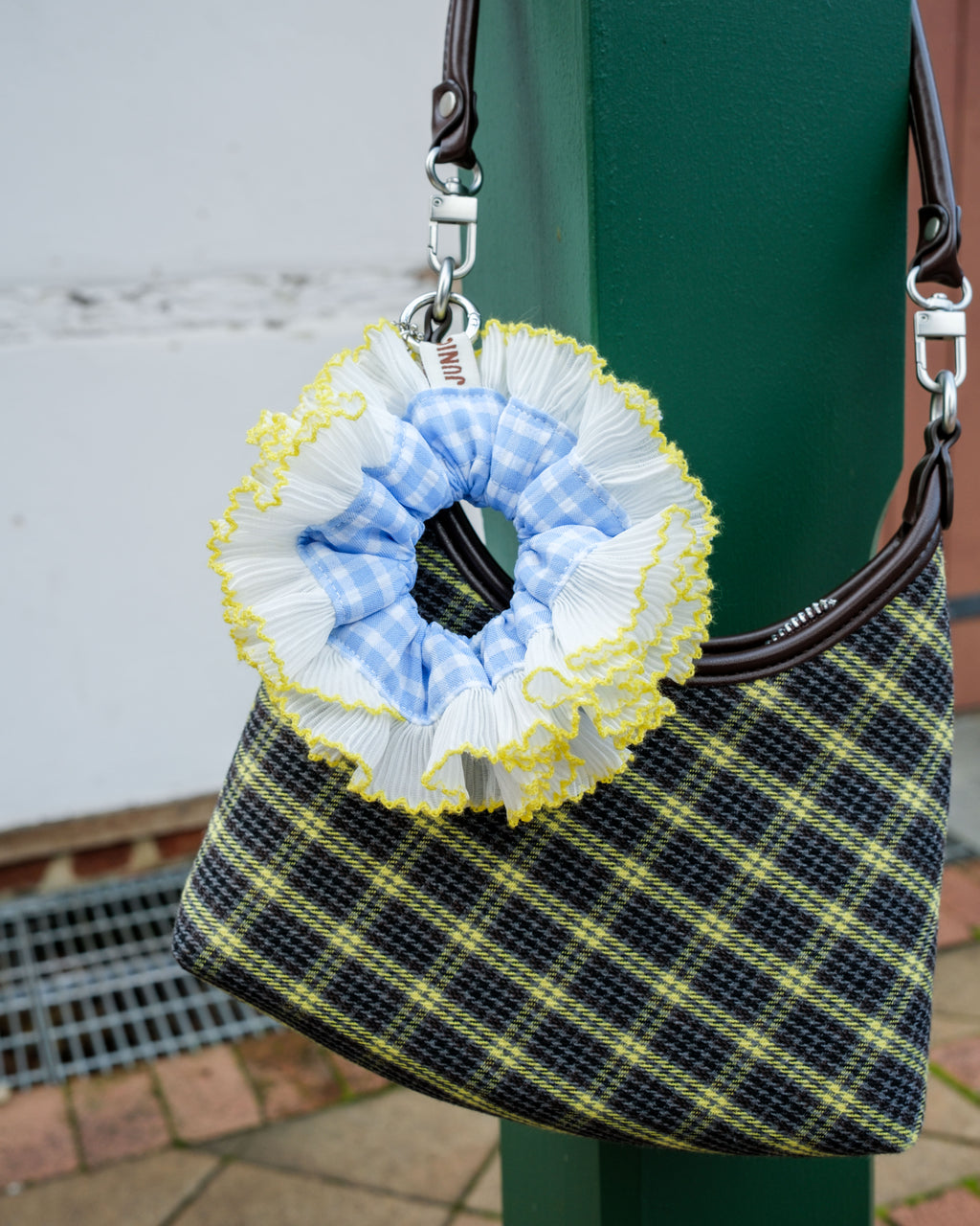 blue white yellow scrunchie bag charm on a pleated bag