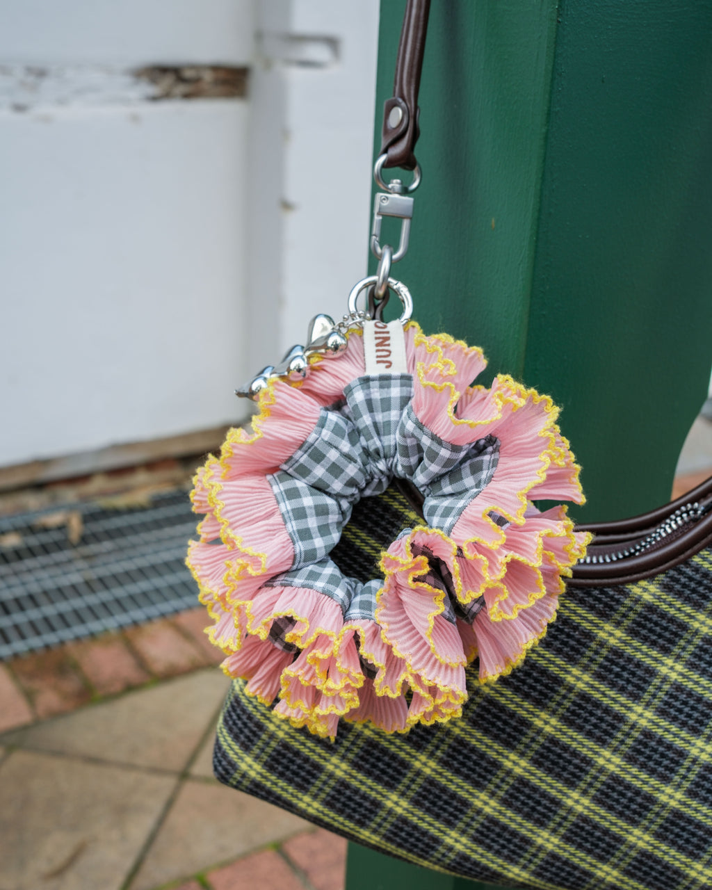sage pink scrunchie bag charm on a plaid bag