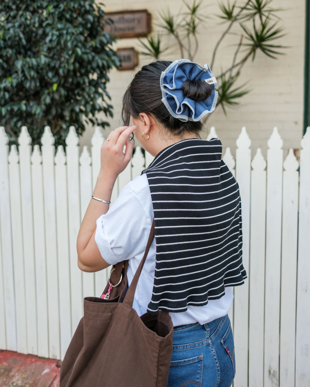model wearing juniq brand scrunchie, chambray, blue color, in her bun